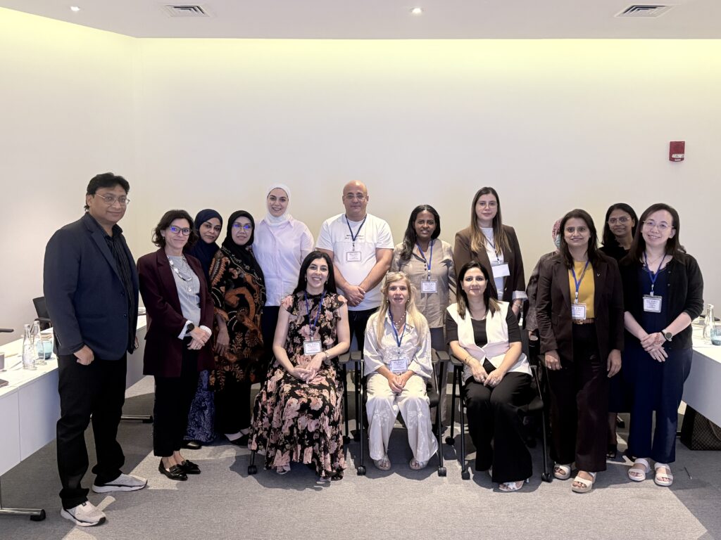 Participants pose together for a formal group photograph in the classroom.