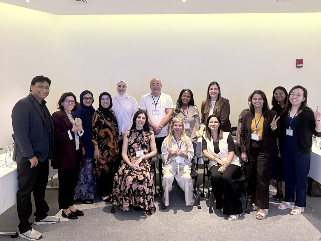 Participants pose together with smiles and hand gestures in the classroom.