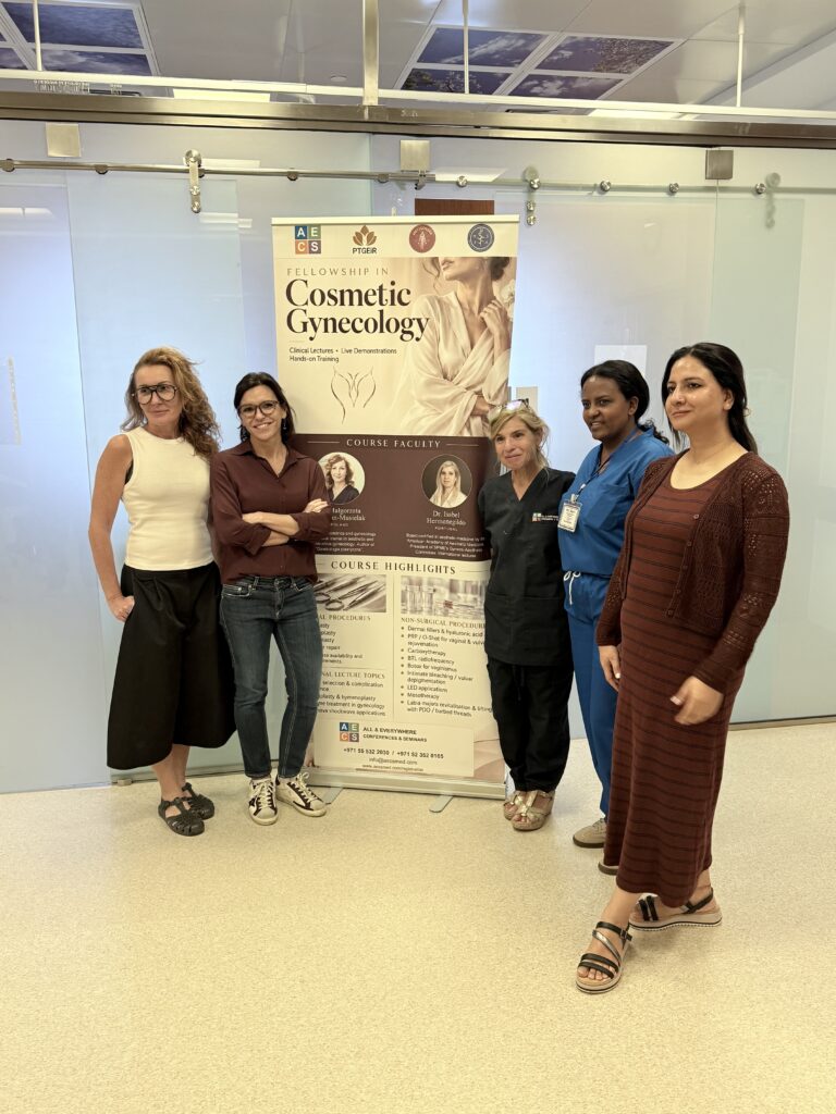 A different group of five women pose beside the course banner.