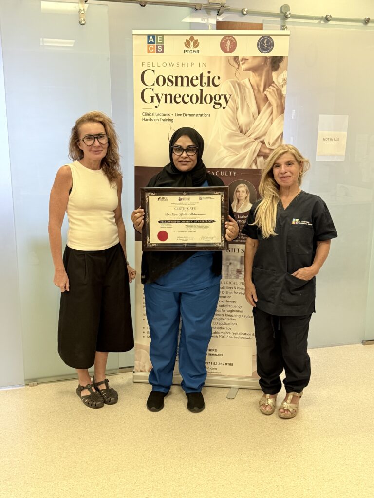 A woman in a black headscarf displays her certificate between two women.