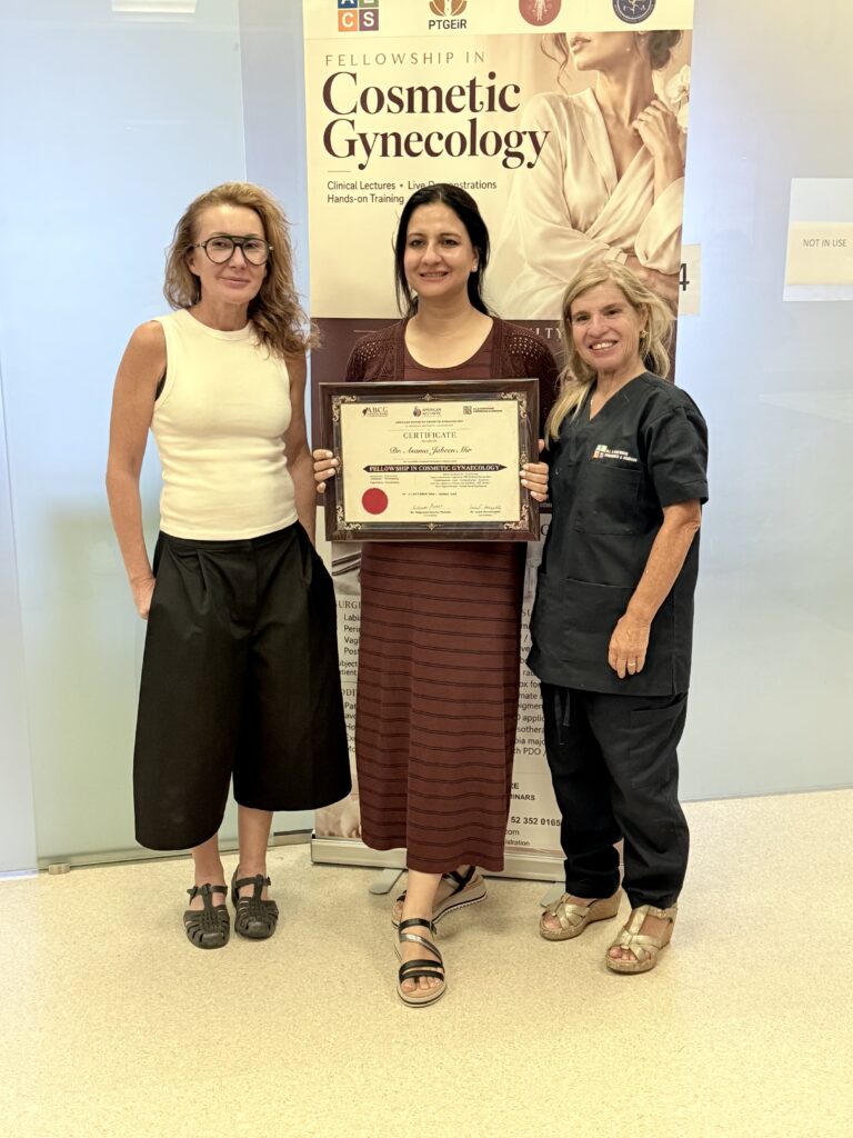 A woman in a burgundy dress displays her course certificate beside two women.