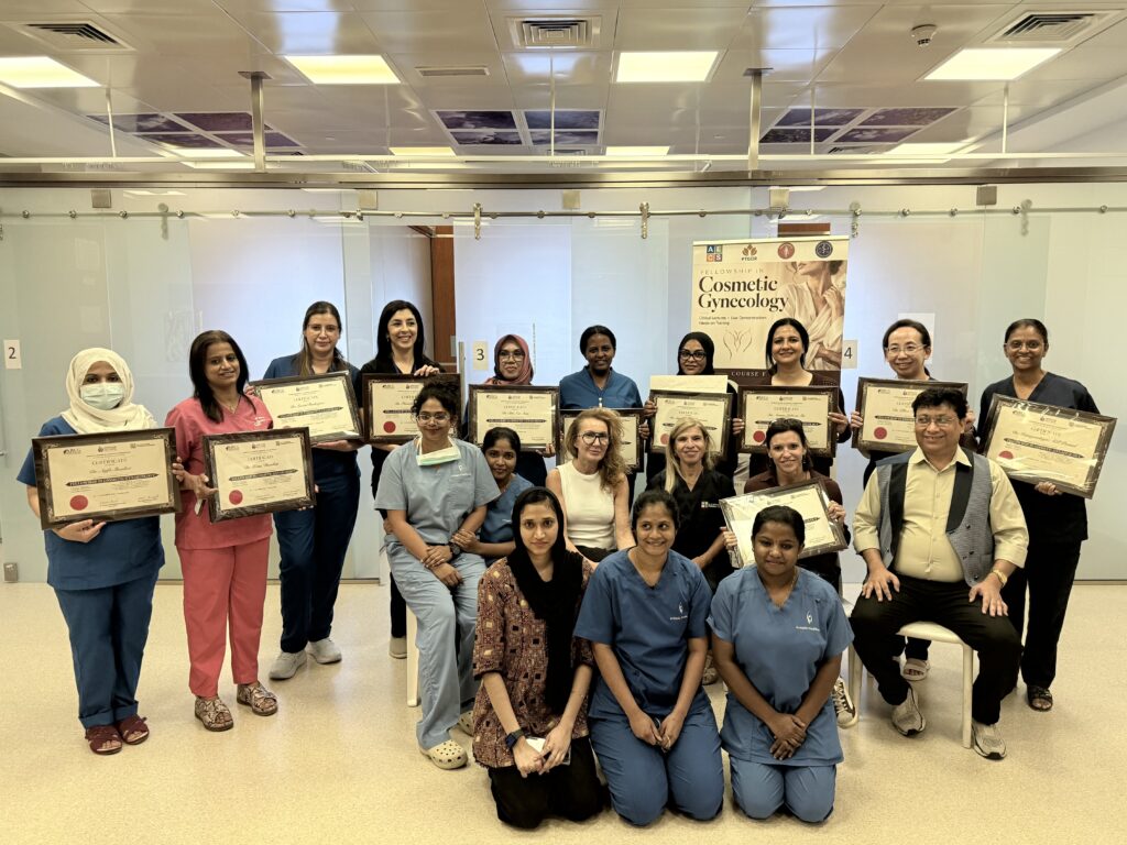 The completed-course group poses together holding certificates in front of its banner.